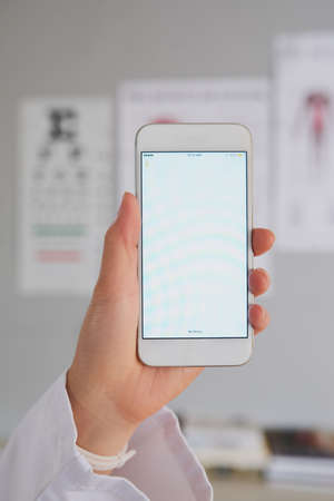 You can reach me on the go. High angle shot of an unrecognizable female doctor sending a text while working in the hospital.の写真素材