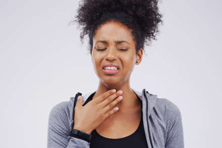 Im struggling to breathe at this point. Studio shot of a young woman suffering with a sore throat...
