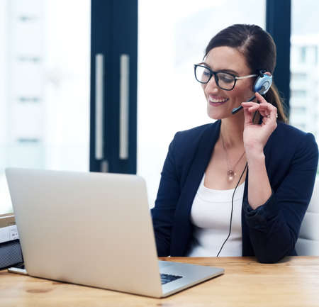 Happy to be the voice of the company. Shot of a happy businesswoman talking on her headset while...