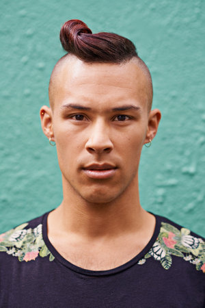 On top of the latest trends. Portrait of a young man with a trendy hairstyle standing outside.