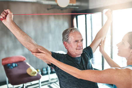 Targeting arm strength with resistance bands. Shot of a senior man using resistance bands with the...