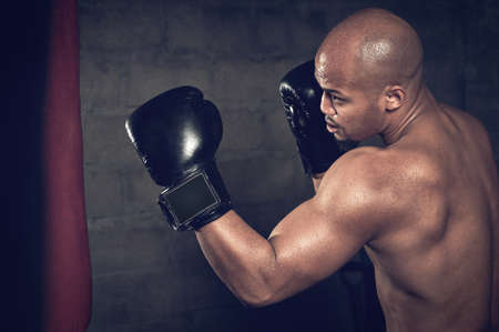 Perfect form. Cropped shot of a young male boxer doing some work on the punching bag.