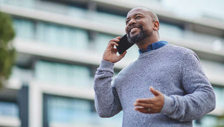 Its great to finally chat to you. Cropped shot of a handsome mature businessman making a phonecall while out in the city.の写真素材