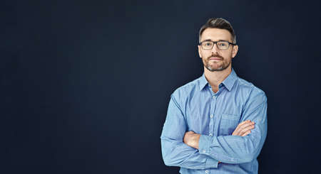 Hes got character and confidence. Studio portrait of a handsome businessman standing with his arms...