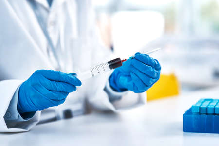 You have to work with extreme caution in the lab. Closeup shot of an unrecognisable scientist using...