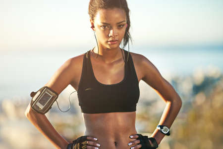 Go beyond your limits. Shot of a young woman exercising outdoors.の写真素材