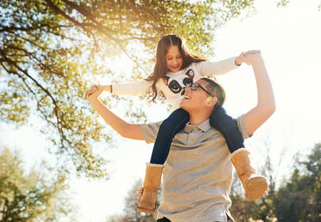 Having fun with my sister. Low angle shot of a teenage boy carrying his adorable little sister on his shoulders outdoors.の写真素材