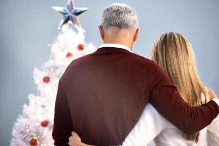 Christmas is such a special time. Rearview shot of a father and daughter standing by their Christmas tree.の写真素材