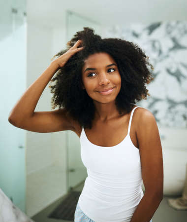 Looking and feeling all refreshed. Shot of an attractive young woman looking at her face in the...