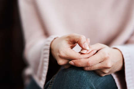 The hands say what the heart feels. Cropped shot of a woman sitting on a sofa and feeling anxious.の写真素材