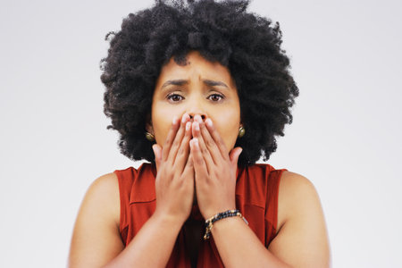 No, it cant be. Studio shot of a young woman looking shocked against a grey background.の写真素材