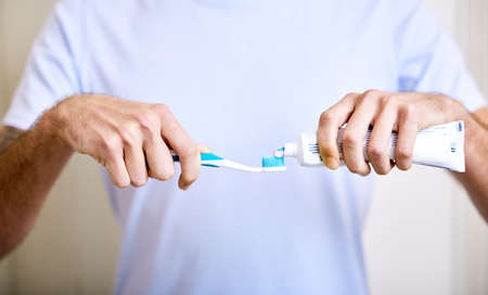 Brushing twice a day keeps the cavities away. Shot of a man applying toothpaste to his toothbrush.の写真素材