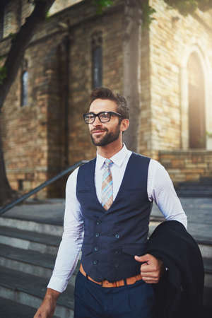 Hes an urban gentleman. Shot of a stylish young man in the city.の写真素材