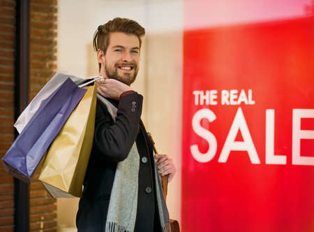 On a bargain hunting mission. Portrait of a happy young man on a shopping spree.