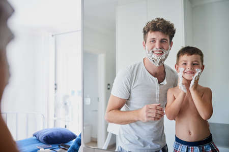 Am I doing it right Dad. Shot of a father teaching his little son how to shave in the bathroom at home.の写真素材