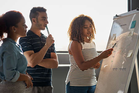 Planning for the success they aim to achieve. Shot of a group of young designers brainstorming on a...