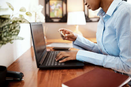 Shopping online saves me so much time. Cropped shot of a businesswoman using a laptop and credit...