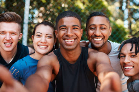Its just smiles all around when were together. Portrait of a group of sporty young people taking selfies together outdoors.の写真素材