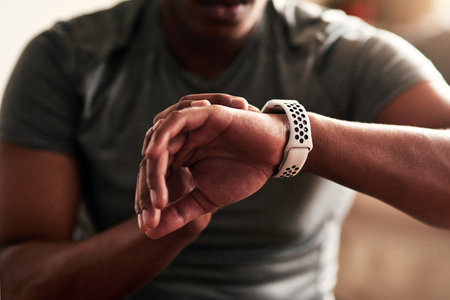 It also tracks your speed and distance traveled. Cropped shot of an unrecognizable man checking his wristwatch.の写真素材