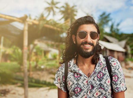 Nothing but blue skies ahead. Portrait of a happy young traveler taking in the sights on an island vacation.の写真素材