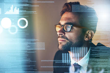 Taking a look at the source code. Cropped shot of a handsome young businessman coding late in the...