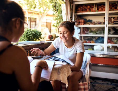 Girls getaway. Cropped shot of a mother and daughter sitting in a cafe while on vacation.の写真素材