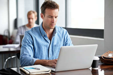 Deadlines are his inspiration. Shot of a man working on a laptop in an office.