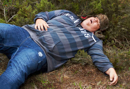 Suffering the consequences of a wild night.... An obese young man lying passed-out outside in the...