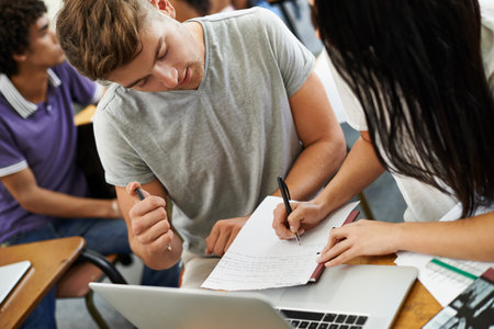 Study partners. A young male and female student studying in a classroom.の写真素材
