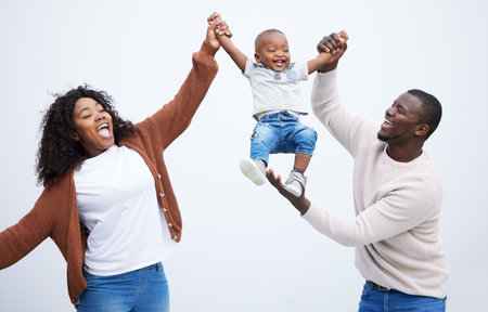 Cherish life. Enjoy it now. Shot of a young couple playing with their son in a park.の写真素材