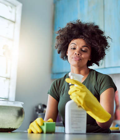 Spring cleaning. Cropped shot of an attractive young woman with yellow gloves cleaning her home.の写真素材