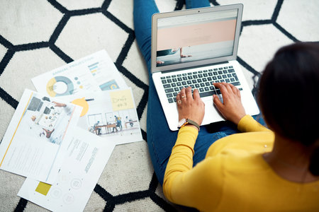 Updating my data. Cropped shot of an unrecognizable woman sitting on the floor and using her laptop...