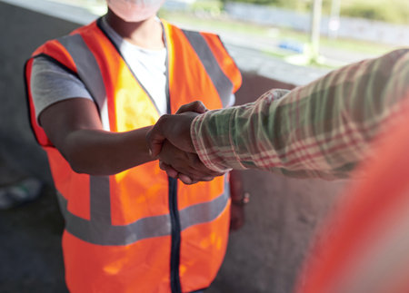 Lets work together to build even better. Shot of two builders shaking hands at a construction site.の写真素材