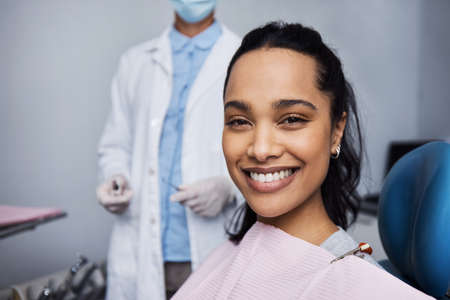 See what good dental health can do for your smile. Portrait of a young woman having dental work done on her teeth.の写真素材