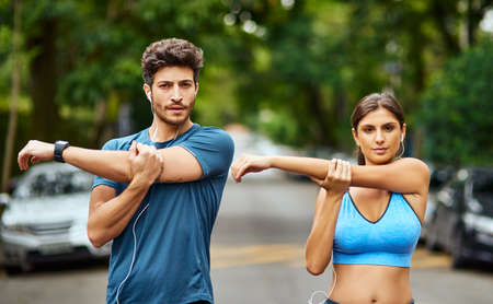 Fitness is our challenge to conquer together. Portrait of a sporty young couple stretching while...