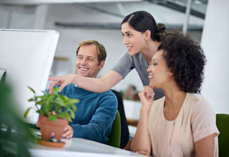 None of us is as smart as all of us. Shot of a group of creative businesspeople working together on...