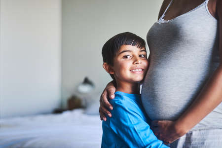 Soon there will be three of us. Cropped portrait of an adorable little boy standing against his...