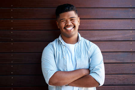 Positivity is best paired with ambition. Portrait of a confident young businessman working in a modern office.の写真素材