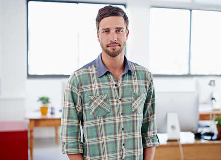 The consummate office professional. Portrait of a stylish young man standing in an office.の写真素材