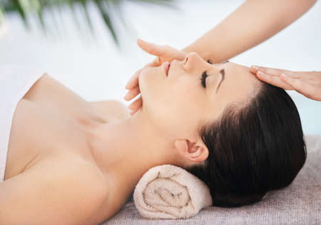 Because beauty matters. A young woman getting a face massage from a massage therapist.の写真素材