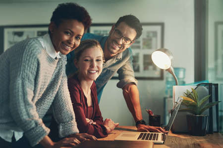 Were the best for a reason. Cropped portrait of three young businesspeople looking at a laptop.の写真素材