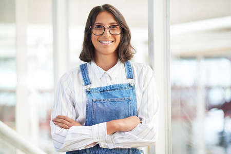 Its the coolest company to work for. Portrait of a confident young businesswoman working in a modern office.の写真素材