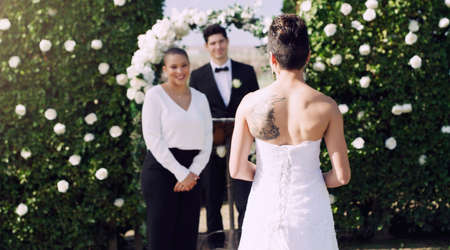 Shes a few steps away from her happiness. Rearview shot of an unrecognizable lesbian bride walking towards the altar on her wedding day.の写真素材