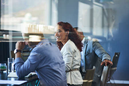On the other side of the glass. Cropped shot of a group of young businesspeople sitting in the...