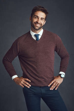 Hes a standup guy. Studio portrait of a stylishly dressed young man posing against a gray background.の写真素材