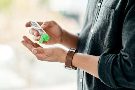 Good hygiene is in your hands. Cropped shot of a businessman using hand sanitiser to disinfect his...