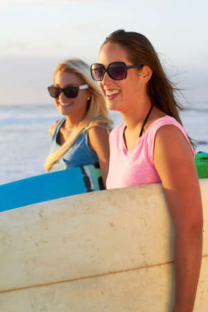 Surfing with my bestie. Cropped shot of two attractive young female surfers.の写真素材