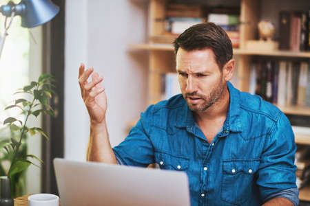 What is happening. Cropped shot of a businessman looking a little frustrated while working at home.