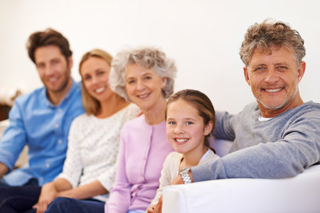 Three generations of love. Portrait of a cheerful multi generational family smiling together.の写真素材