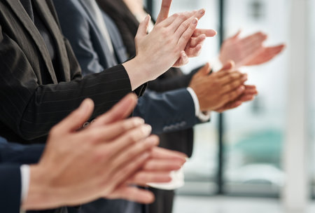 Great presentation are motivational. Closeup shot of a group of executives clapping while standing in a row in an office.の写真素材
